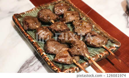 Close up of Japanese three skewers of grilled chicken gizzard on a plate in izakaya restaurant  126081974
