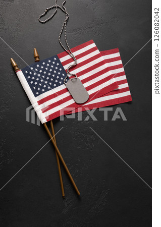Military ID Dog Tag Hanging with American Flags on black background Military ID Dog Tag Hanging with American Flags on black background 126082042