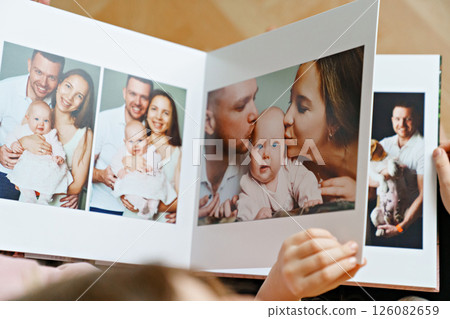 hands flip through the pages of a photo book with family photos. hands flip through the pages of a photo book with family photos. 126082659