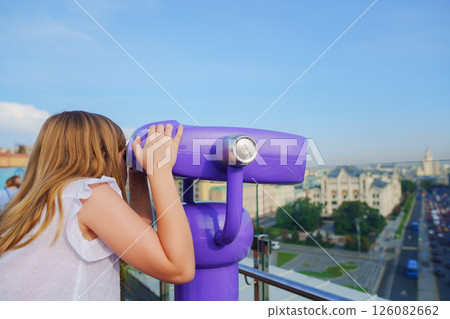 a teenage girl looks into the Binoscope from the observation deck at a height. a teenage girl looks into the Binoscope from the observation deck at a height. 126082662
