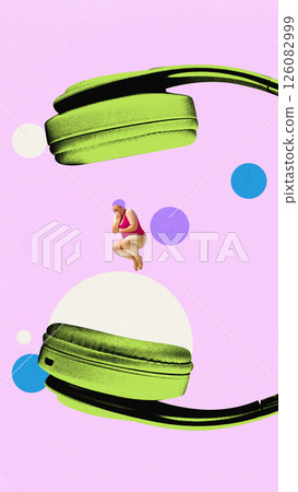 Woman in swimsuit jumping on giant headphones with colorful circles backdrop. Woman in swimsuit jumping on giant headphones with colorful circles backdrop. 126082999