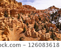 An aerial of Dixie National Forest in Utah.  Photographed from a high point of view using a drone.  Snow scattered among the pine trees and red rock hoodoos. 126083618