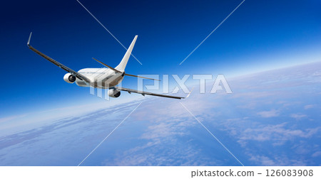 White passenger airplane flying above beautiful earth and clouds 126083908