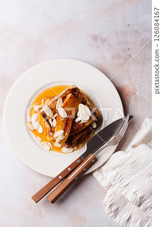 French toast with caramelized banana, syrup and almonds. French toast with caramelized banana, syrup and almonds. 126084167