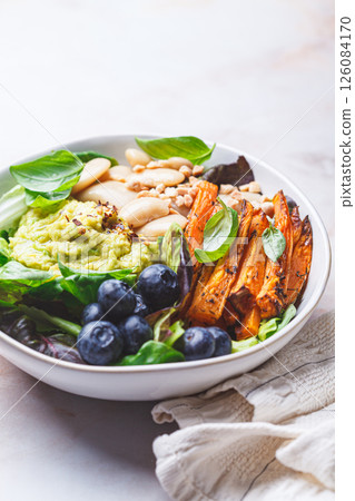 Vegan bowl with butter beans, baked sweet potatoes, guacamole, berries and spinach. Vegan bowl with butter beans, baked sweet potatoes, guacamole, berries and spinach. 126084170