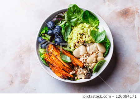 Vegan bowl with butter beans, baked sweet potatoes, guacamole, berries and spinach. Vegan bowl with butter beans, baked sweet potatoes, guacamole, berries and spinach. 126084171