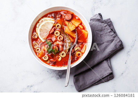 Traditional soup solyanka with smoked sausages, olives and potatoes. Traditional soup solyanka with smoked sausages, olives and potatoes. 126084181