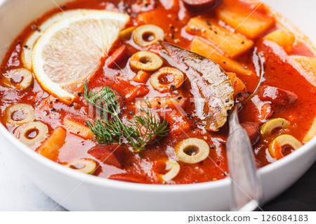 Traditional soup solyanka with smoked sausages, olives and potatoes. Traditional soup solyanka with smoked sausages, olives and potatoes. 126084183