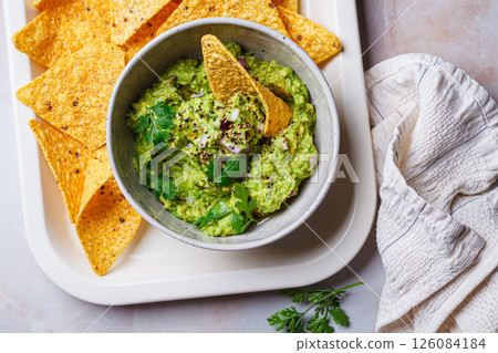 Avocado guacamole spread with nacho corn chips. Avocado guacamole spread with nacho corn chips. 126084184