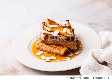 French toast with caramelized banana, syrup and almonds. French toast with caramelized banana, syrup and almonds. 126084201