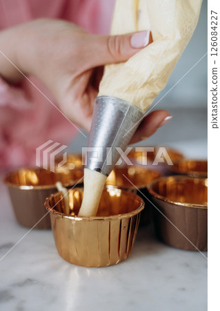 Decorated Cupcakes in Golden Foil Cups with Icing 126084227
