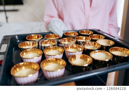 Preparing Muffin Batter in Gold Cups for Baking Preparing Muffin Batter in Gold Cups for Baking 126084228