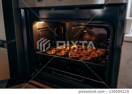 Baking Cupcakes in Oven with Metallic Cupcake Trays 126084229