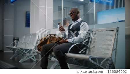 Airport Terminal: Successful Man with Luggage Using Smartphone, Waiting for Flight 126084902