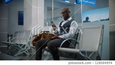Departure Lounge of Airline Hub: Businessman with Bag Using Smartphone 126084954