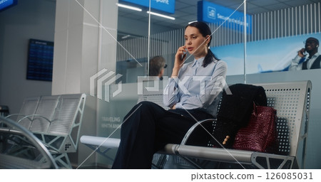 Airport Terminal: Successful Businesswoman Talking on Mobile Phone, Waiting for Airplane Flight Airport Terminal: Successful Businesswoman Talking on Mobile Phone, Waiting for Airplane Flight 126085031