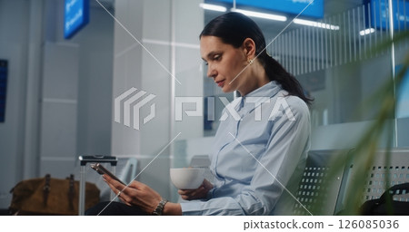 Airport Terminal: Businesswoman Using Smartphone and Drinking Coffee, Sending e-Commerce Emails 126085036