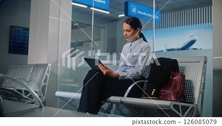 Airport Terminal: Successful Businesswoman Using Digital Tablet, Looking at Camera Airport Terminal: Successful Businesswoman Using Digital Tablet, Looking at Camera 126085079