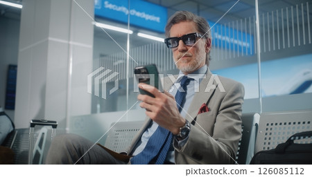 Airport Terminal: Successful Businessman Scanning Boarding Pass Using Smartphone Airport Terminal: Successful Businessman Scanning Boarding Pass Using Smartphone 126085112