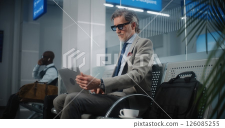 Successful Businessman Using Laptop and Drinking Coffee, Waiting for Flight in Departure Lounge 126085255