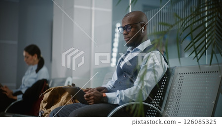 Businessman Using Digital Tablet and Smartphone, Waiting for Flight in Departure Lounge Businessman Using Digital Tablet and Smartphone, Waiting for Flight in Departure Lounge 126085325