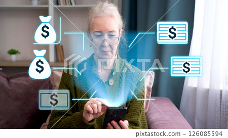 Senior woman interacting with augmented reality financial icons on smartphone at home 126085594