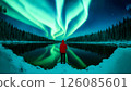 Enchanting northern lights dance over winter forest reflections 126085601