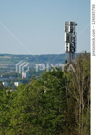 A tall tower with a lot of antennas on top of it 126085798