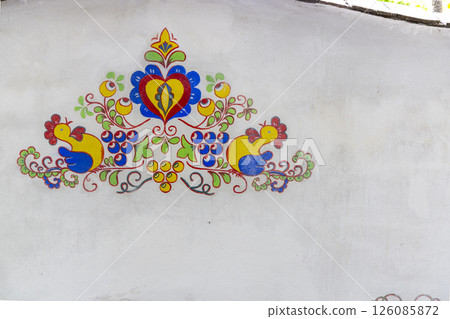 Colorful traditional Polish folk art painting decorating a white wall Colorful traditional Polish folk art painting decorating a white wall 126085872