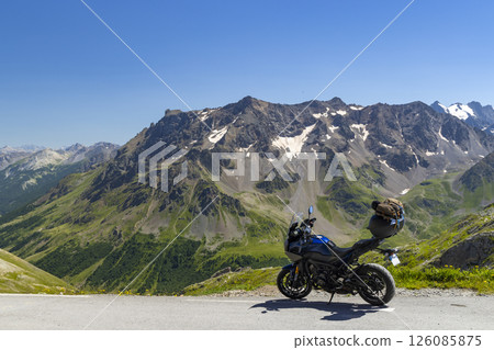 Motorcycle parked on mountain road enjoying breathtaking Alps landscape 126085875