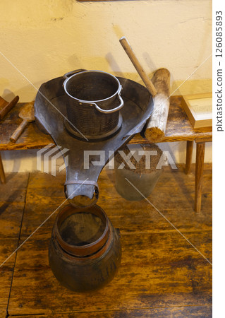 Old metal colander draining into wooden bucket on rustic table Old metal colander draining into wooden bucket on rustic table 126085893