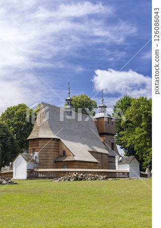 Wooden Church of All Saints standing in Jasienica Rosielna, Poland, under a blue sky 126086043