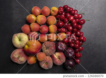 Colorful fresh summer fruits forming a gradient on dark background 126086070