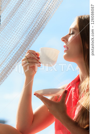 Woman looking through window, relaxing drinking coffee 126086087