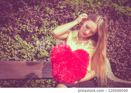 Disappointed woman with big red heart Disappointed woman with big red heart 126086090