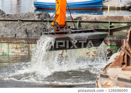 Excavator shovel digging in sand from water Excavator shovel digging in sand from water 126086095