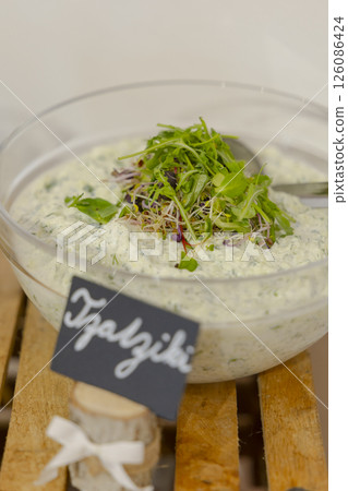 Tzatziki sauce decorated with fresh sprouts in glass bowl 126086424
