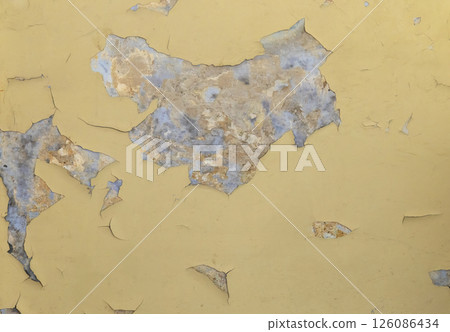 Peeling yellow paint revealing old wall texture creating abstract pattern 126086434