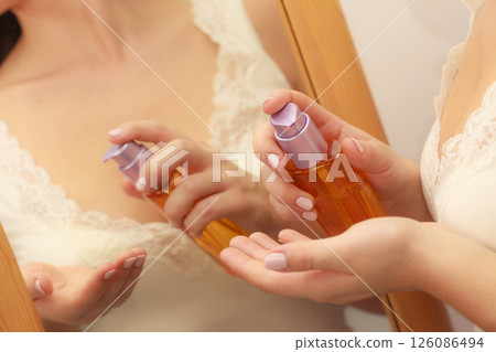 Woman applying body oil lotion cream on her body 126086494