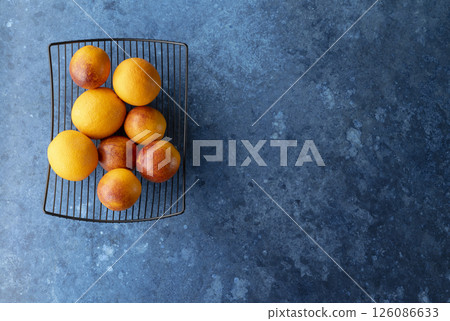 Oranges placed on a wire rack over a textured blue surface Oranges placed on a wire rack over a textured blue surface 126086633