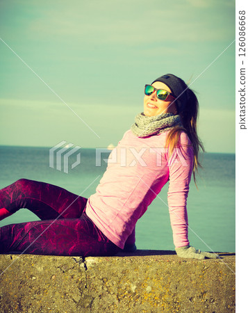Woman resting after doing sports outdoors on cold day Woman resting after doing sports outdoors on cold day 126086668