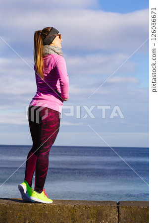 Woman resting after doing sports outdoors on cold day 126086671