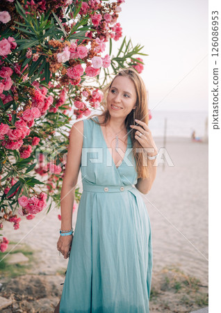 Elegant Woman Posing with Pink Flowers Outdoors Elegant Woman Posing with Pink Flowers Outdoors 126086953