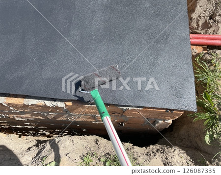 Bitumen rubber waterproofing mastic applied to surface 126087335