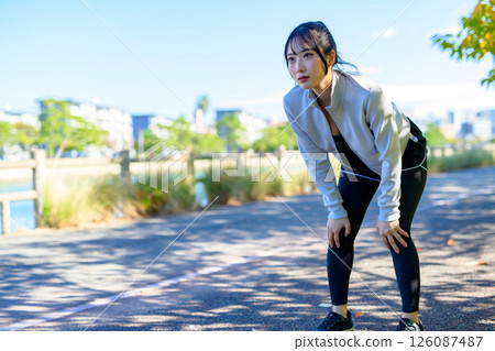 Running and getting out of breath, Out of breath, Cool woman jogging along the river 126087487