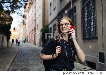 Young woman talking on smartphone while walking outdoors 126088106
