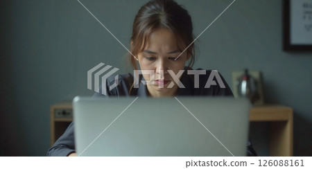 Stressed employees working at laptops showing fatigue and frustration during long work hours 126088161