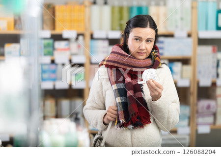 Middle-aged woman having sore throat in drugstore 126088204