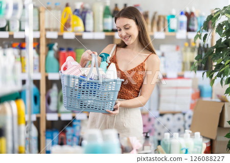 Young woman chooses household chemicals in store 126088227