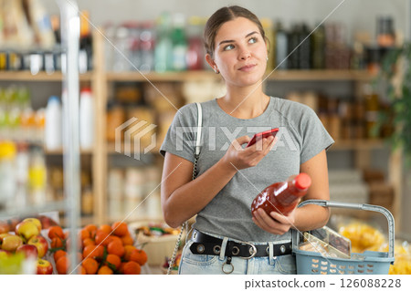 Young woman scanning qr code of tomato juice Young woman scanning qr code of tomato juice 126088228
